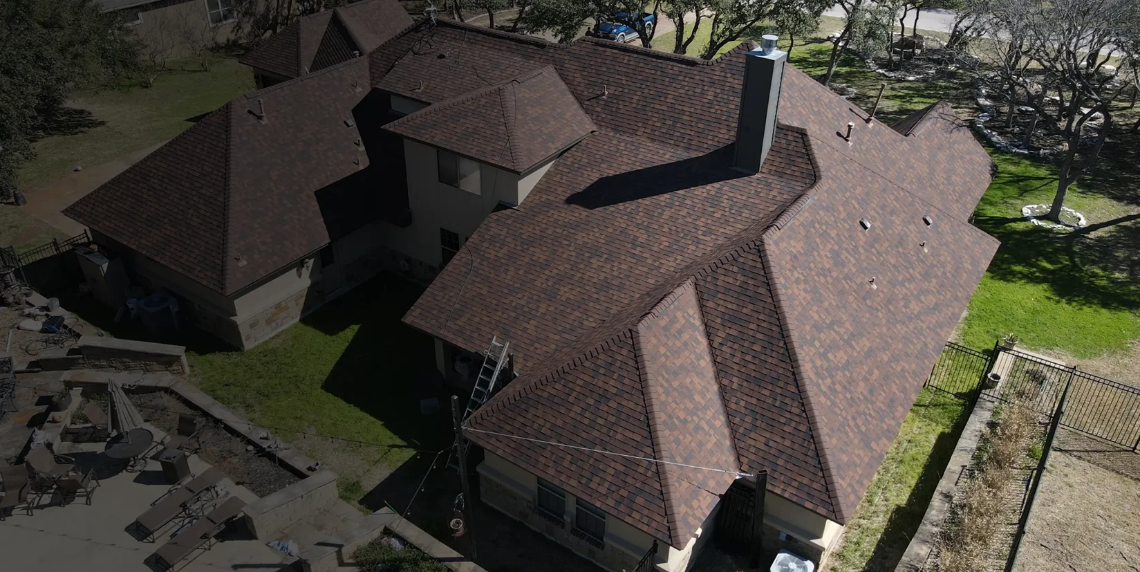A shingle roof with intersecting rooflines, dormers and a chimney, viewed from above