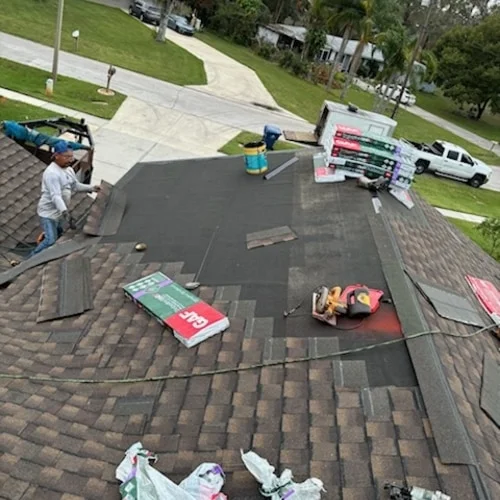 Roofers installing underlayment and shingles on a roof